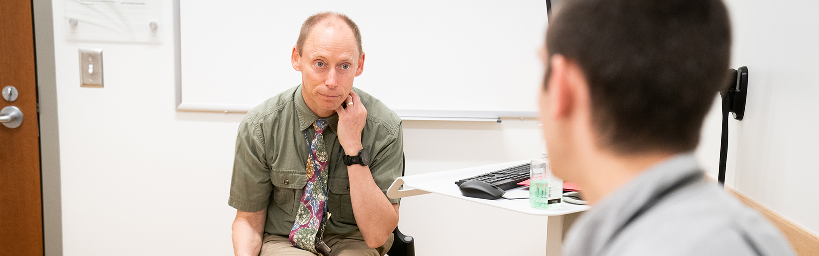 male doctor offering feedback to young male physician