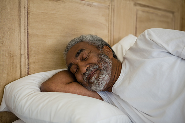 African American elderly man sleeping in a bed